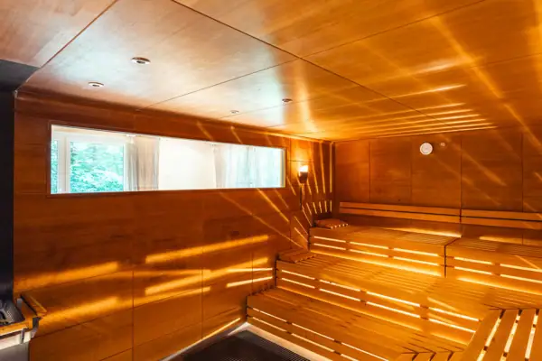 Wooden sauna with sun rays shining through the walls