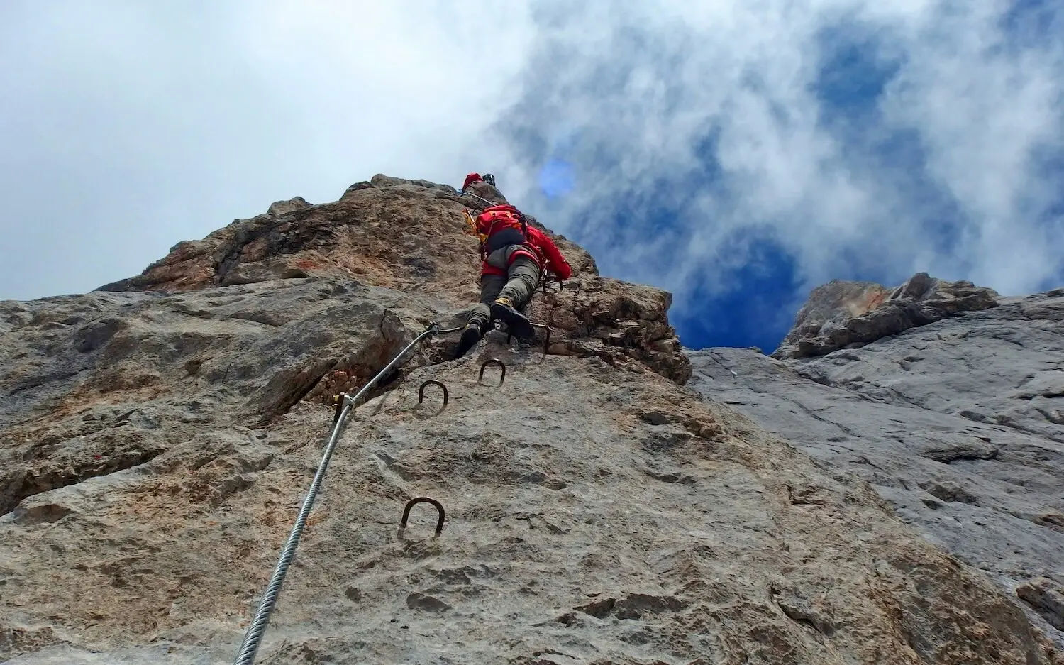 Person climbing on a rock face in the open air.