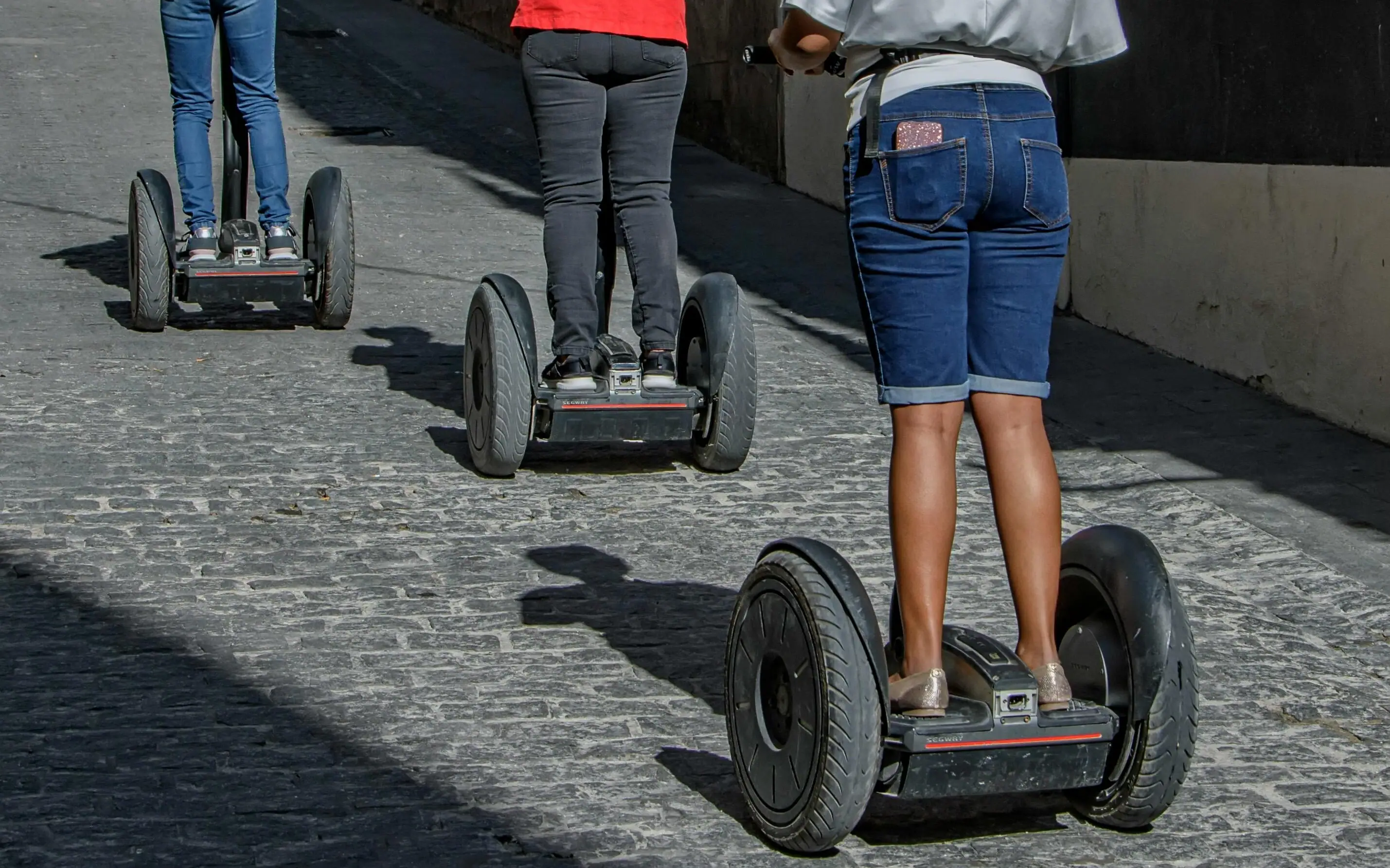 Group of people on Segways outdoors at sunset.