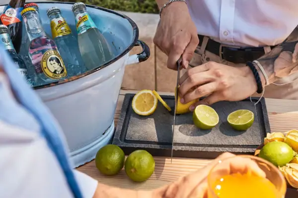 One person cuts a lemon with a knife.