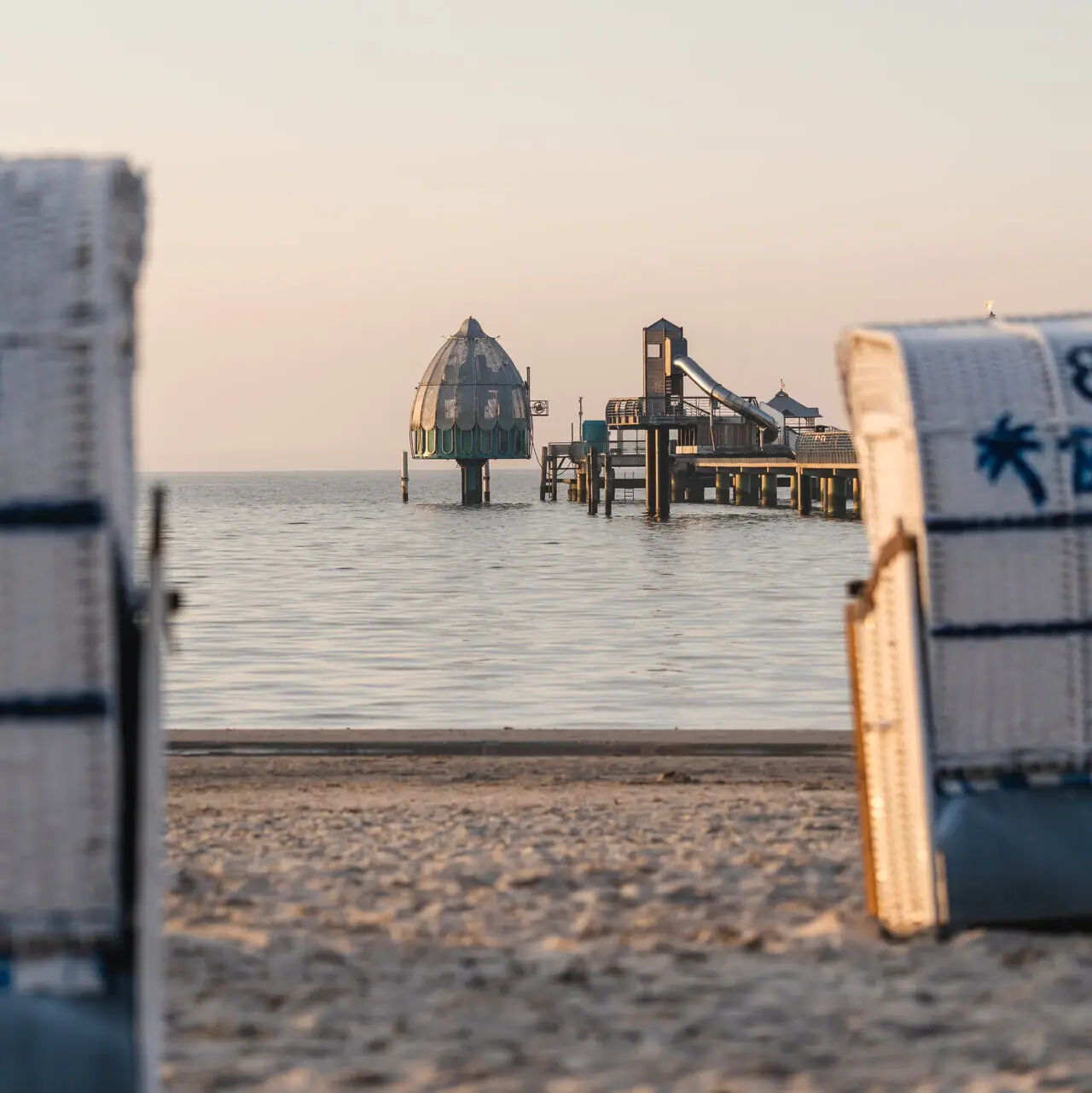 Beach chairs on the beach with a view of the water and the Grömitz diving gondola.
