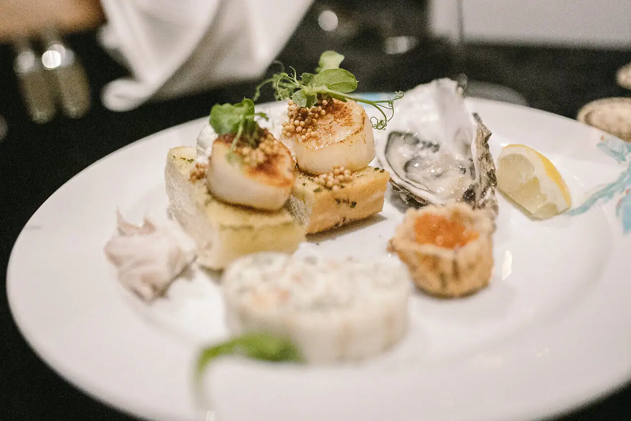 A plate of food, various snacks such as scallops.