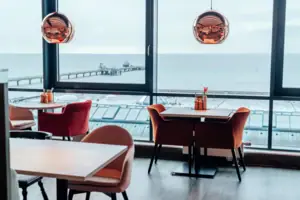 A room with a view of the ocean and a pier.