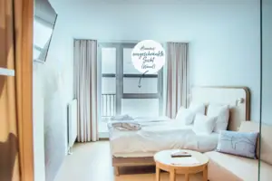 aja economy room A bed in a room with a table and chairs.