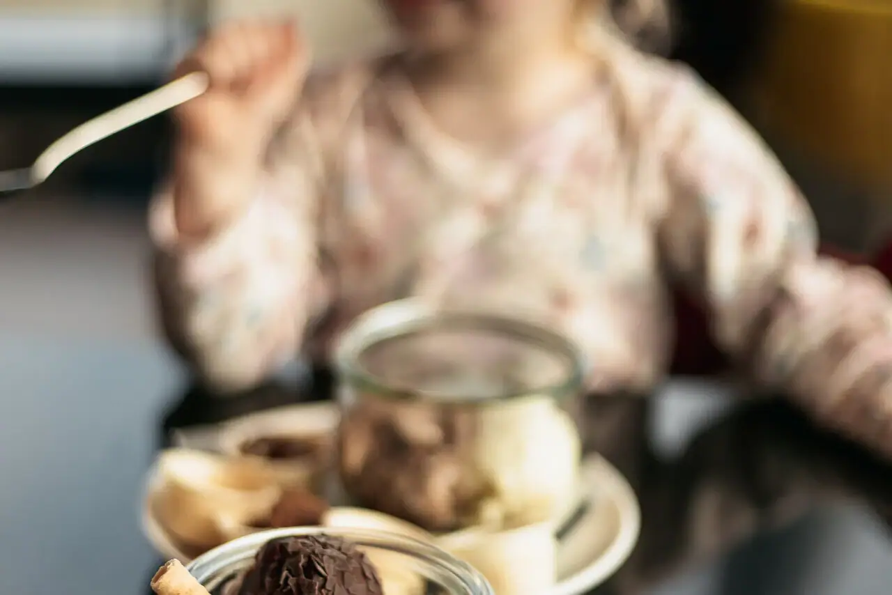 A toddler eats ice cream.