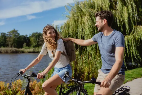 A man and a woman are cycling outdoors.