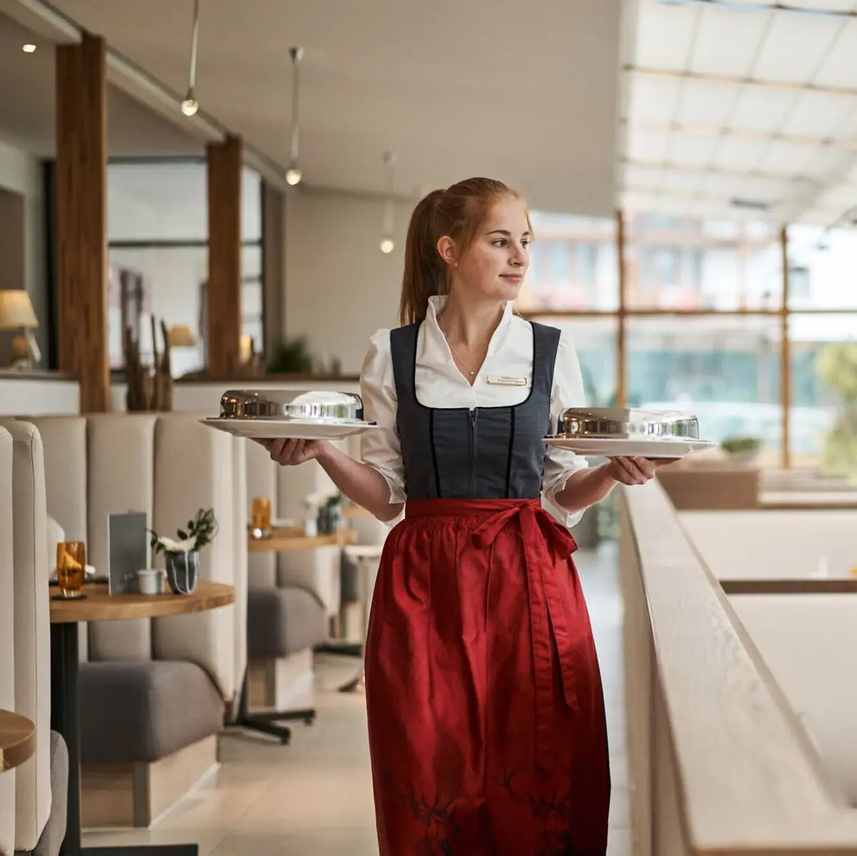 Service employee A woman holds two plates.