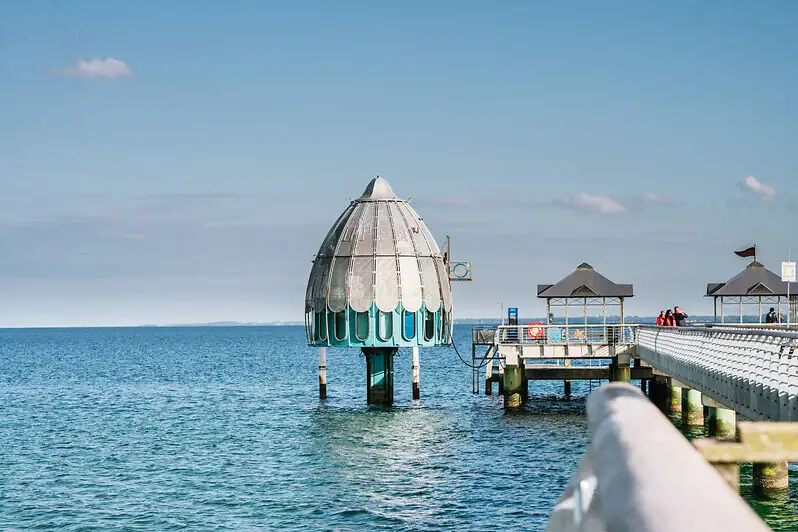A building in the water under a cloudy sky.