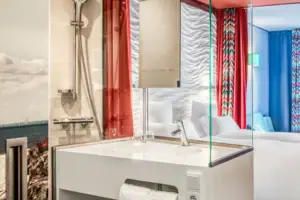 A room with a double bed and a washbasin.