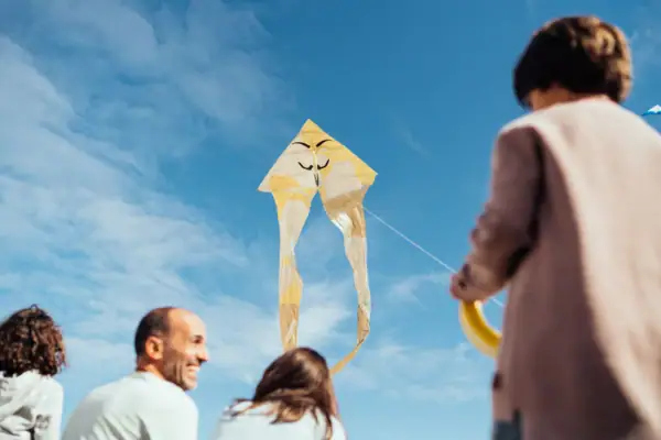 A group of people fly a kite.