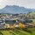 View of a town in the valley with surrounding mountains and a railroad line in the foreground.