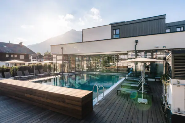 A swimming pool with a deck and chairs.