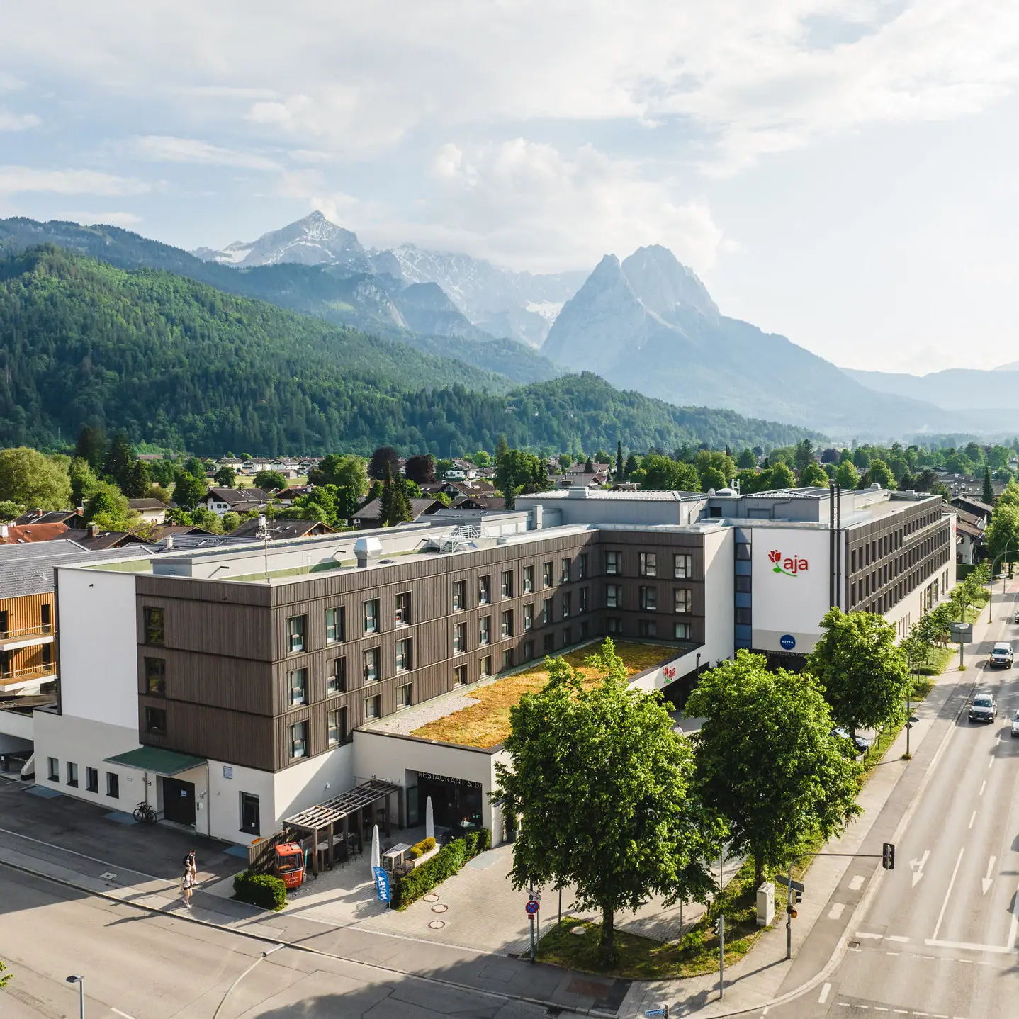 A building with trees and mountains in the background.