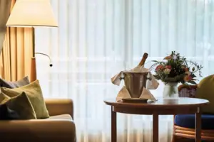 A table with a bucket of champagne and flowers on it.