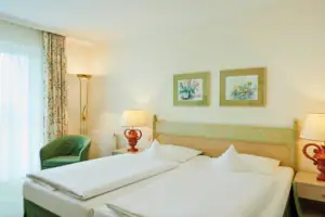 Double room facing the lake A room with two beds and a lamp.