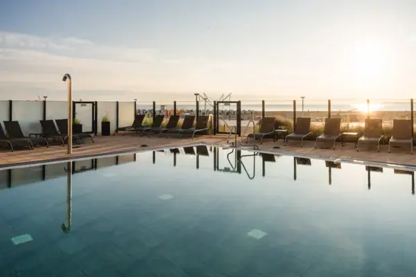 Ein Außenpool mit Liegestühlen und Blick auf die Ostsee.