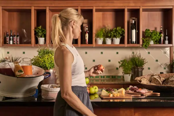 Woman holding an apple in a kitchen