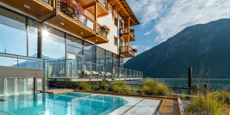 Swimming pool next to a building with mountain views.