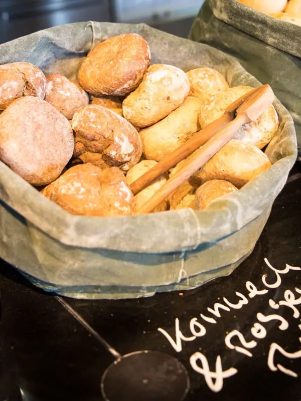 Breakfast at JEDERMANNS A selection of loaves of bread in baskets.