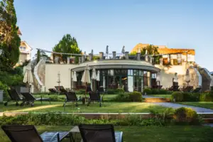 North Perd & Villas Lawn with chairs and parasols in front of a building