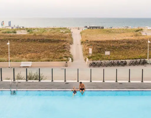 Outdoor pool at the aja Warnemünde A man and a child in a swimming pool.