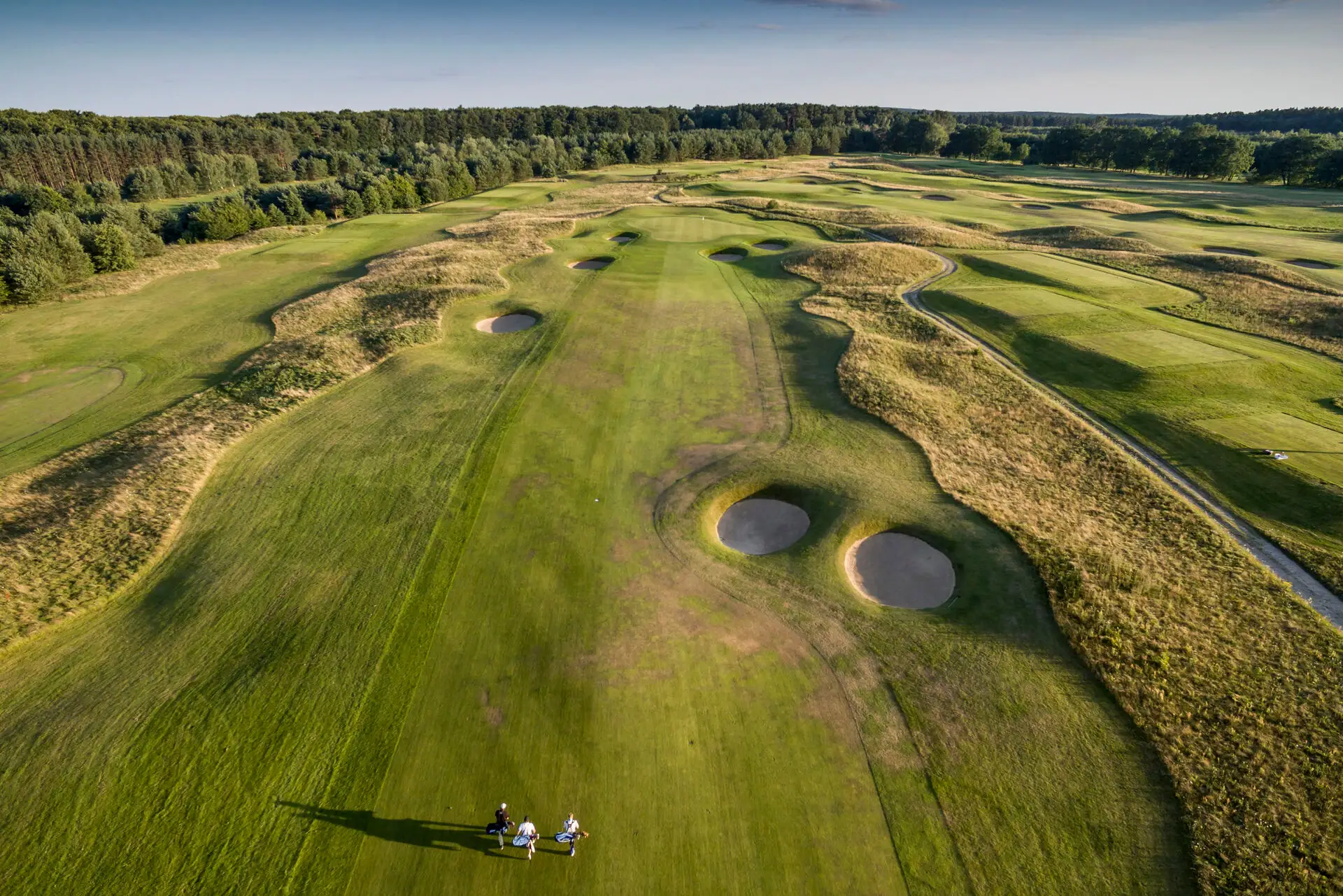 A group of people on a golf course.
