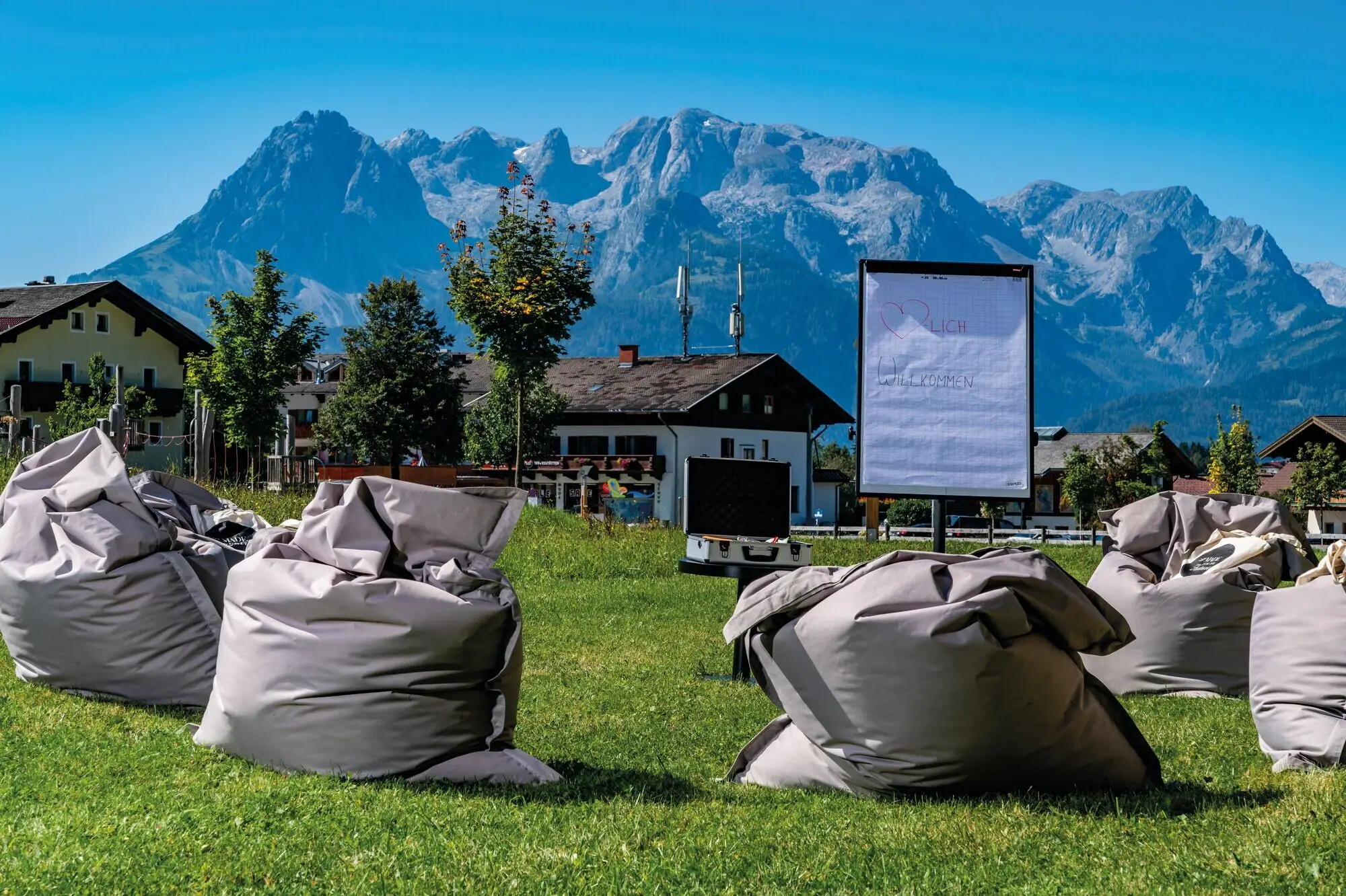 Outdoor meeting Group of beanbags on a meadow with mountains in the background.