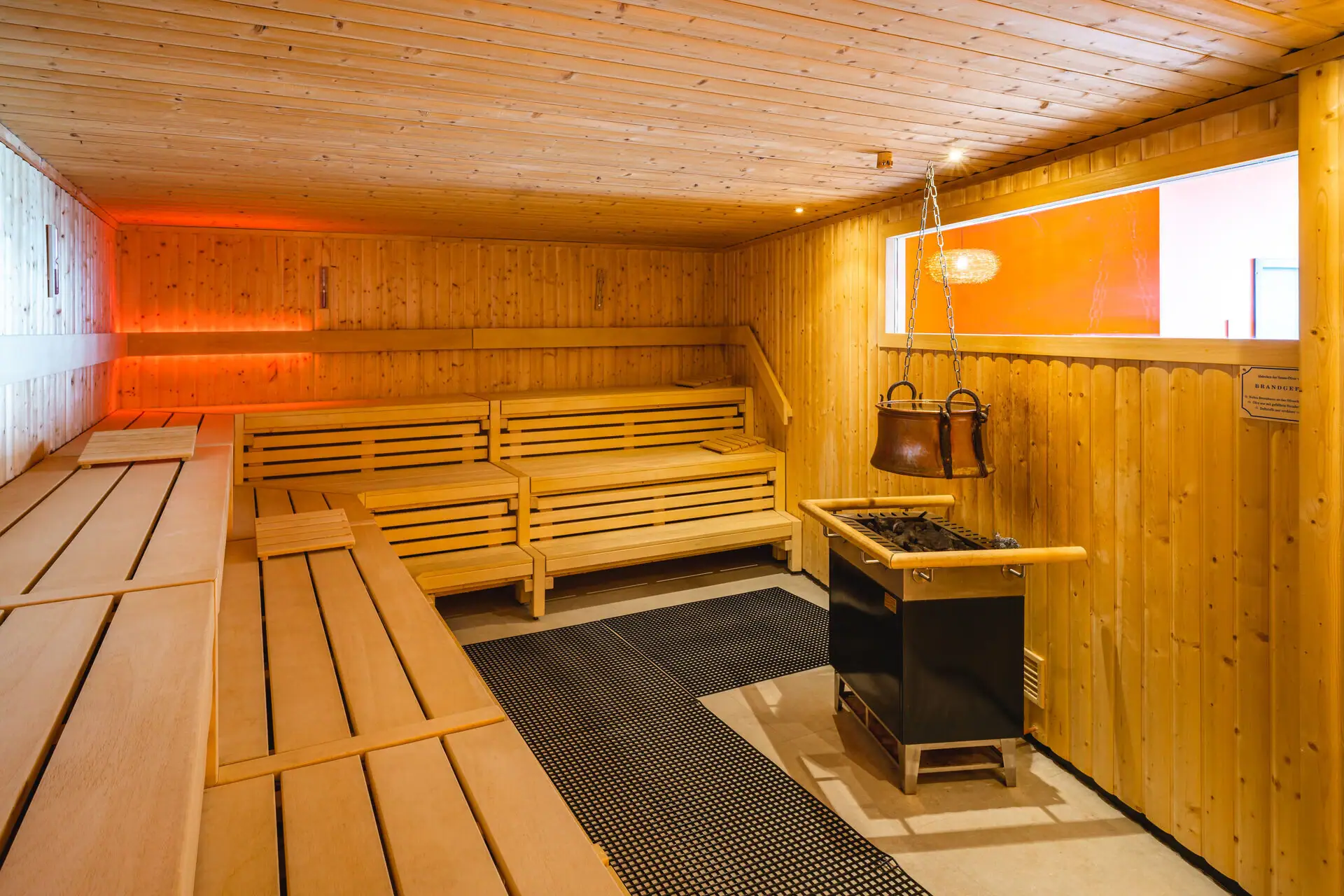 A sauna with benches and a stove.