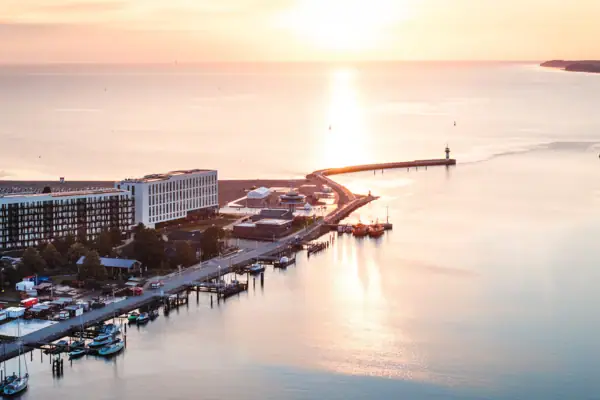 A body of water with a pier and buildings in the background.