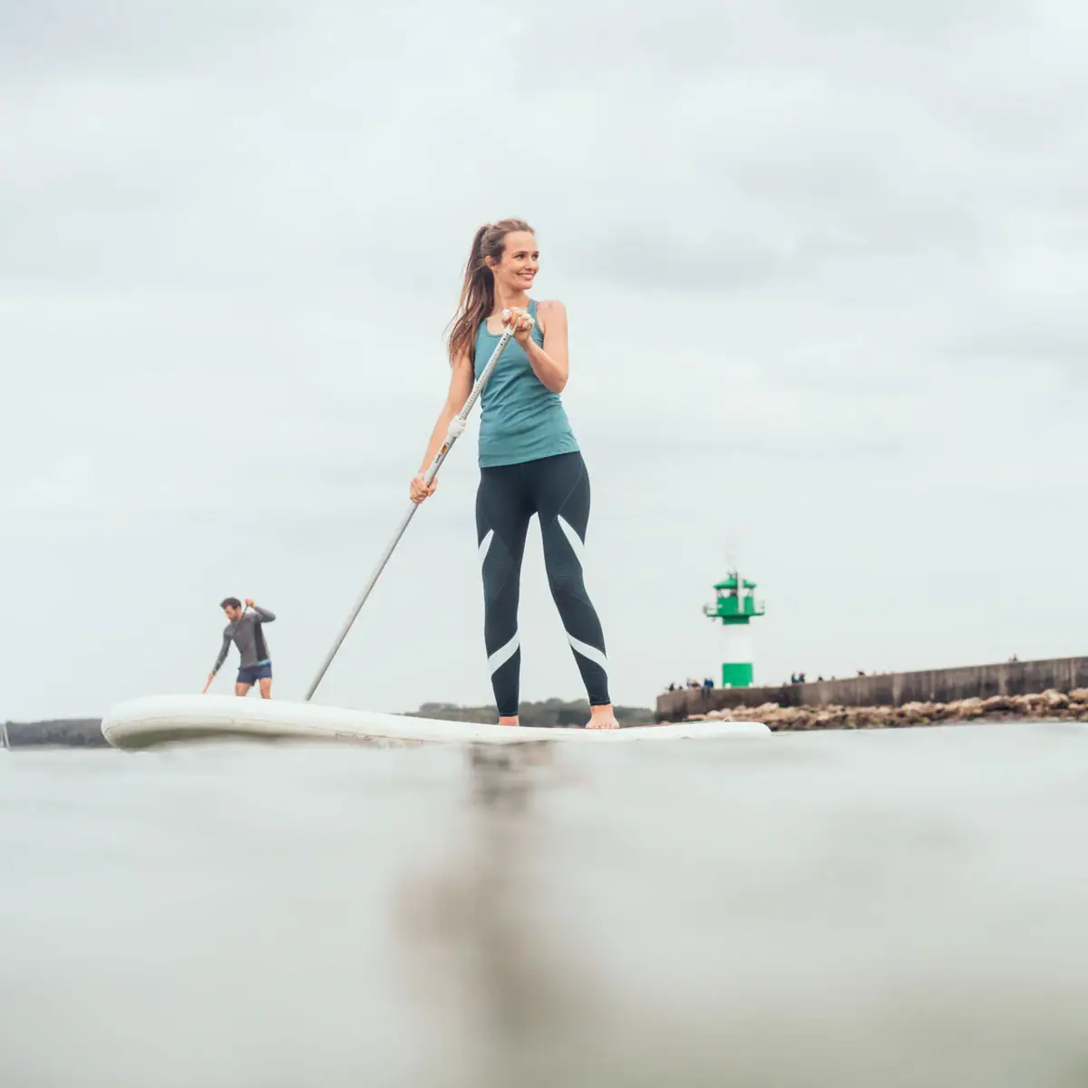 SUP on the Baltic Sea A woman and a man on a surfboard on the water.