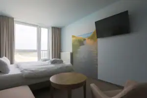 Double room  A room with a bed, a table and a television.