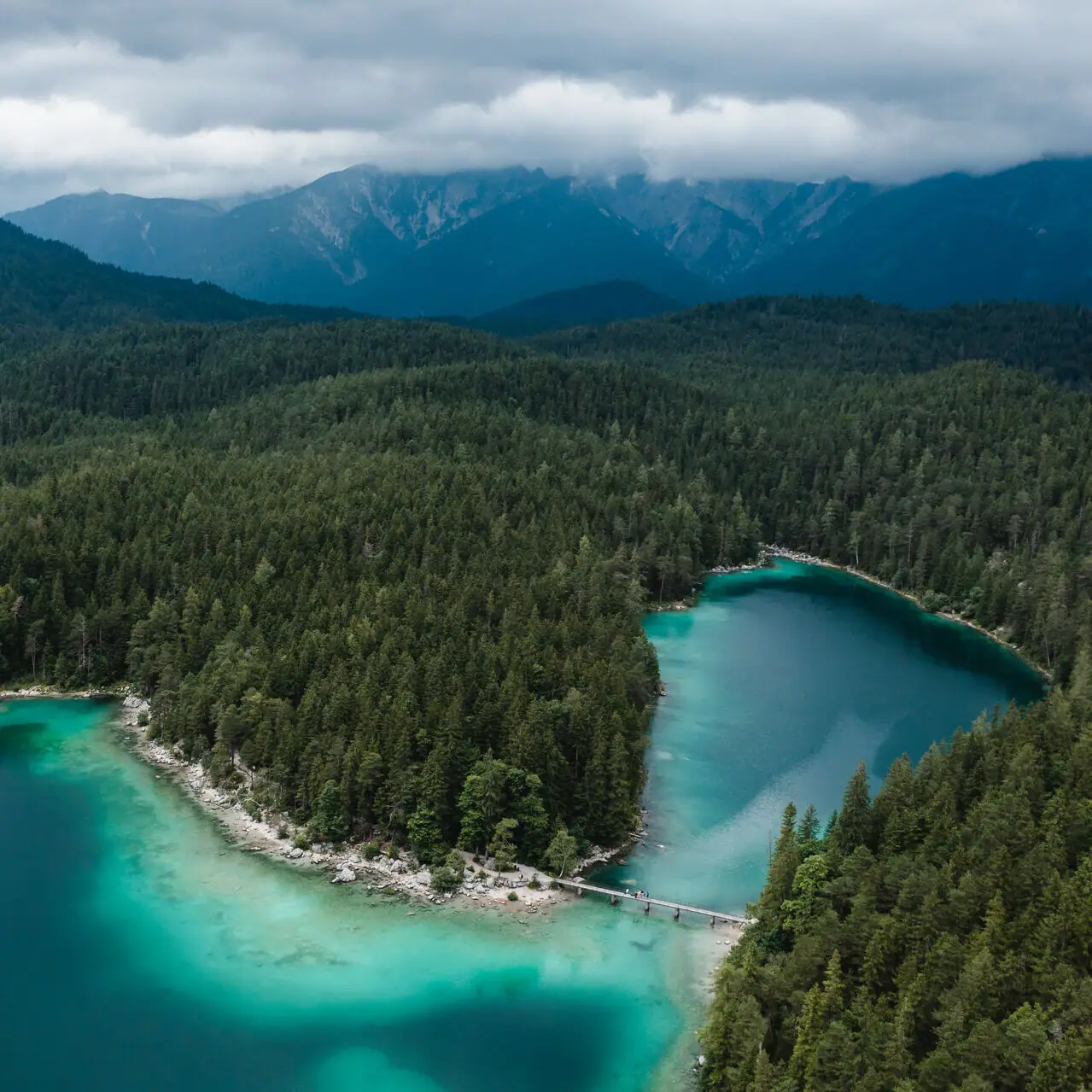 Eibsee A body of water with trees and mountains in the background.