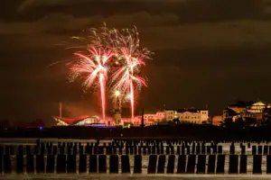 Fireworks lighting up the night sky over a city.