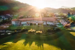 Großes Gebäude mit großem Rasen und Parkplatz im Vordergrund.