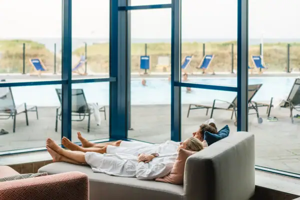 Relaxation area at the aja Warnemünde A couple is lying on a sofa.