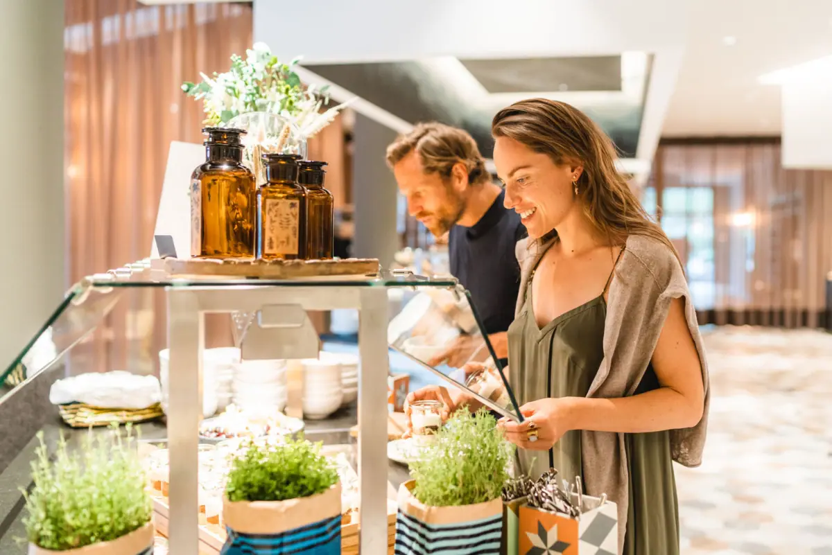 A woman is standing in front of a buffet.
