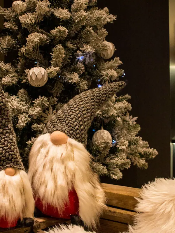 Christmas decorations Two elves are sitting on a bench next to a Christmas tree.