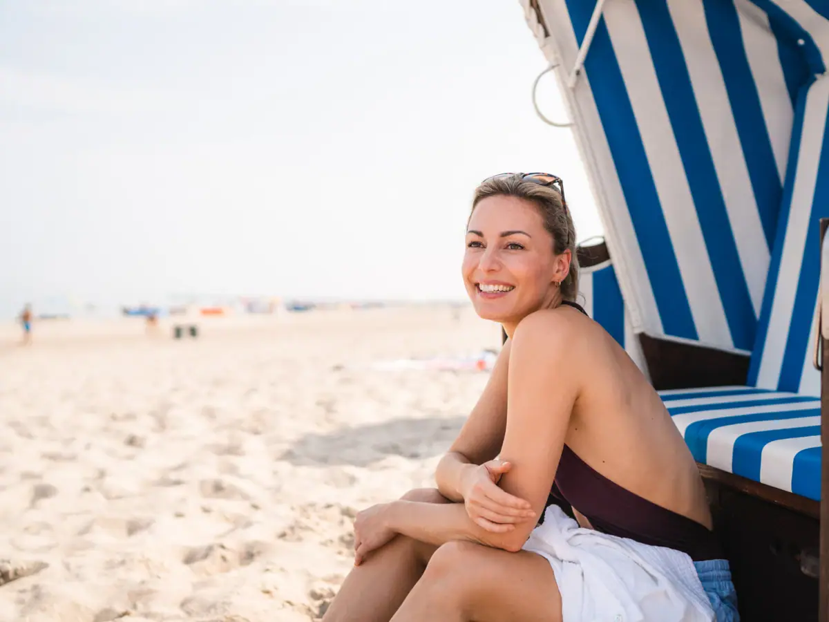 A woman sits in a beach chair.