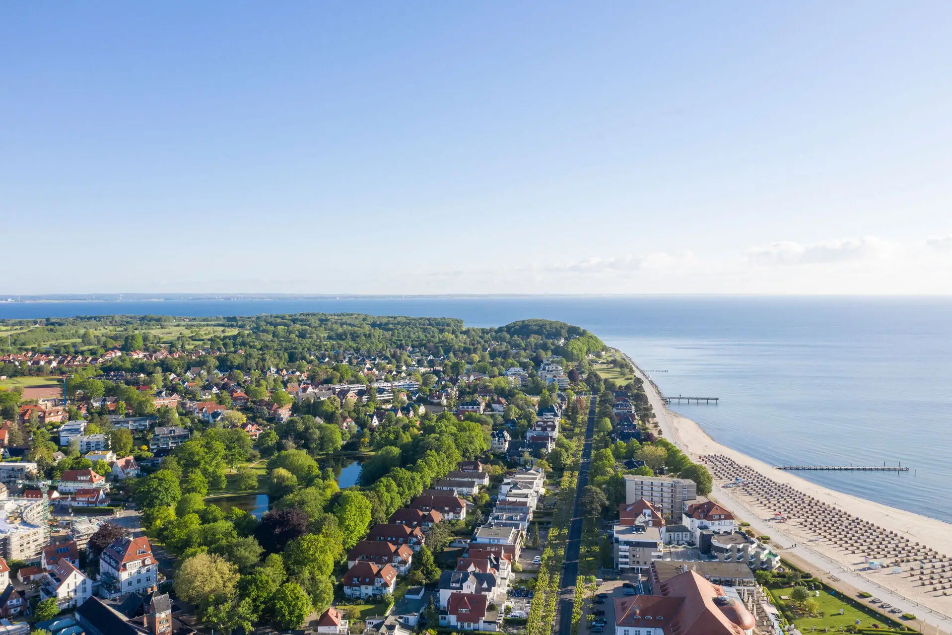 Travemünde coast Aerial view of a town on the water with buildings and trees in the foreground.
