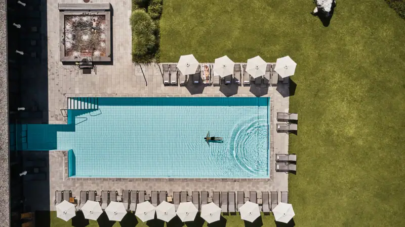 Pool area at aja  Swimming pool with parasols and lawn.