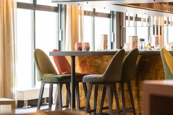 A room with a bar and chairs.
