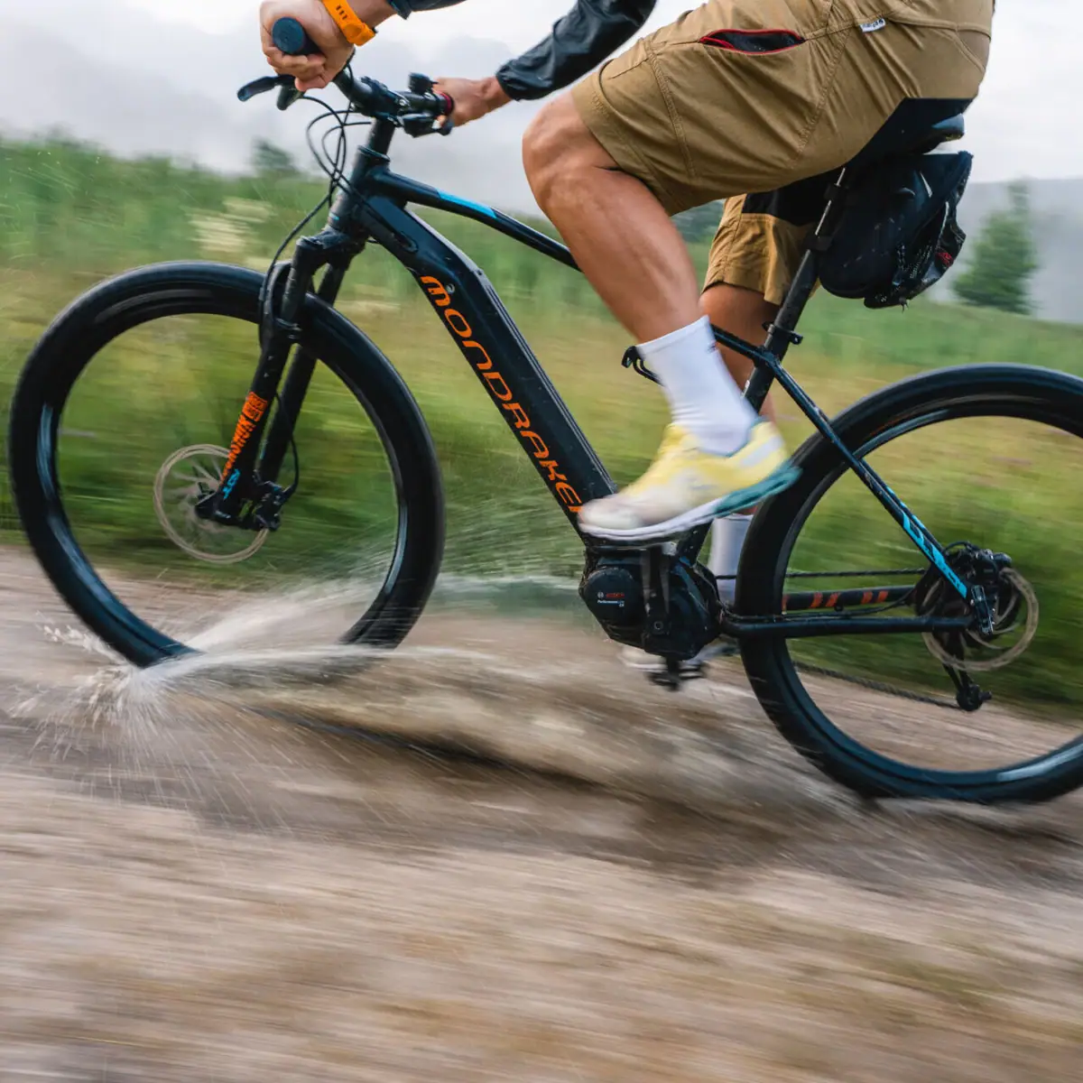 Mountain biking A person rides a mountain bike through a puddle.