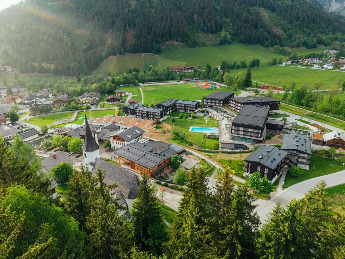 A town with lots of buildings and a swimming pool in the middle of a valley.