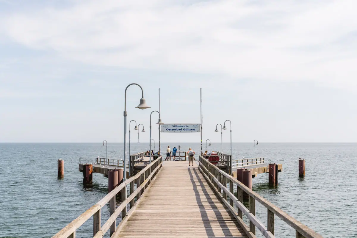 Wooden footbridge with people walking on it.