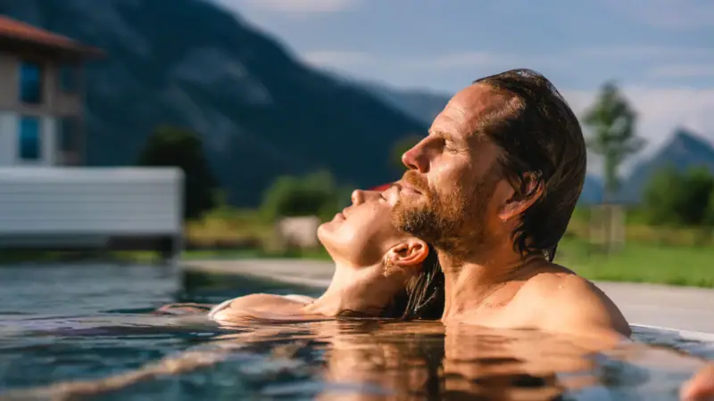 Outdoor pool at aja Ruhpolding A man and a woman in a pool.