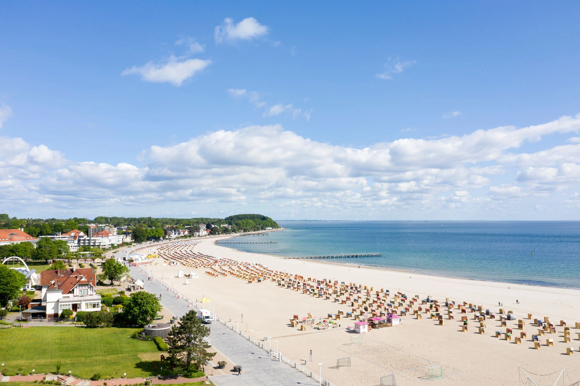 Beach with lots of chairs and a body of water in the background.