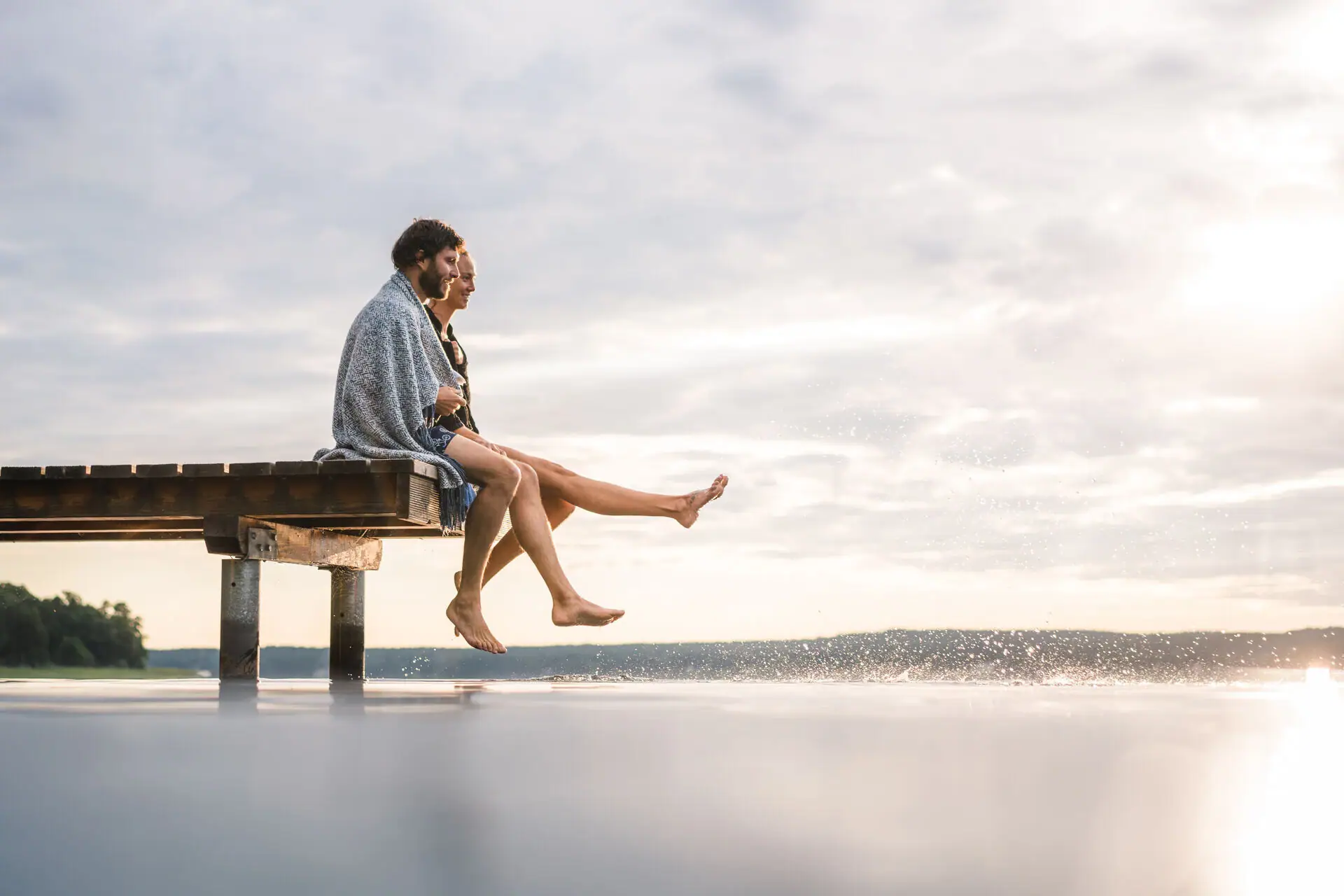 A man and a woman are sitting on a footbridge.
