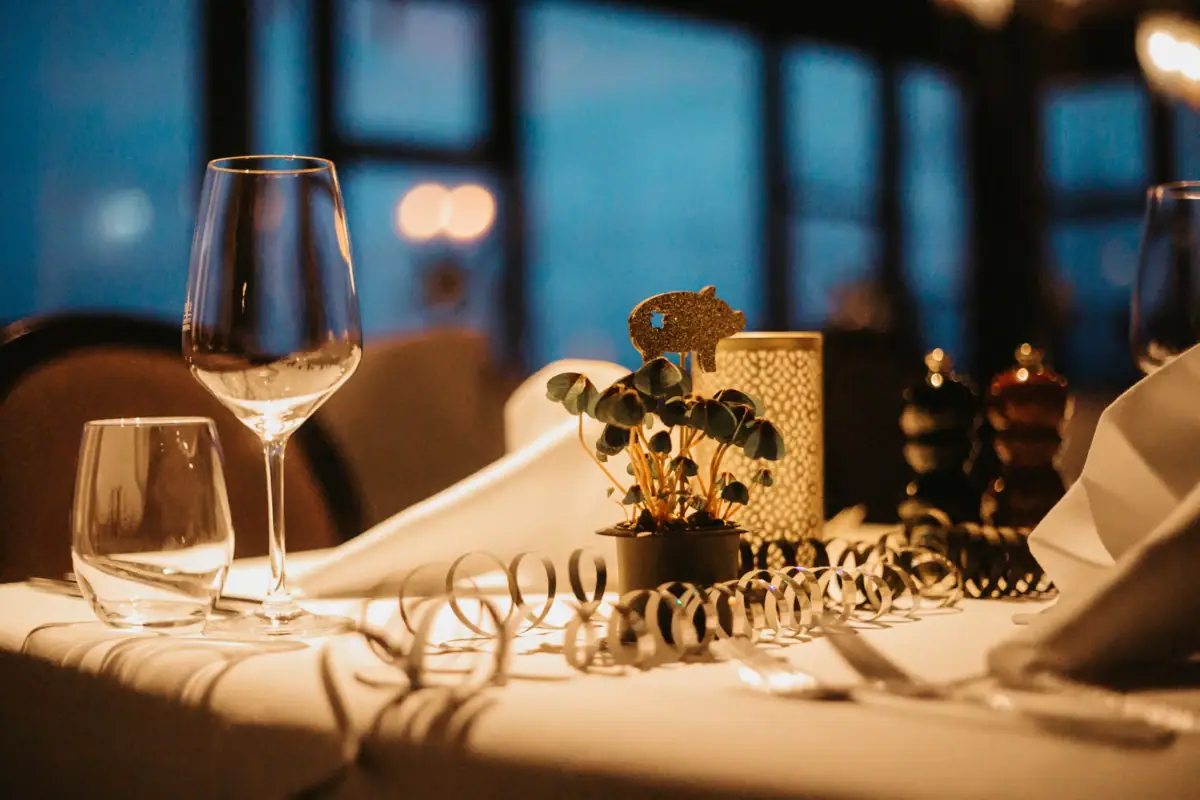 A table with a wine glass and a plant on it.