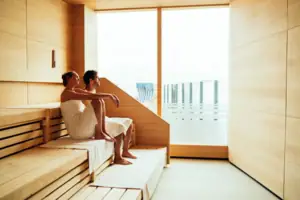Sauna Ein Mann und eine Frau sitzen auf einer Bank in einer Sauna.