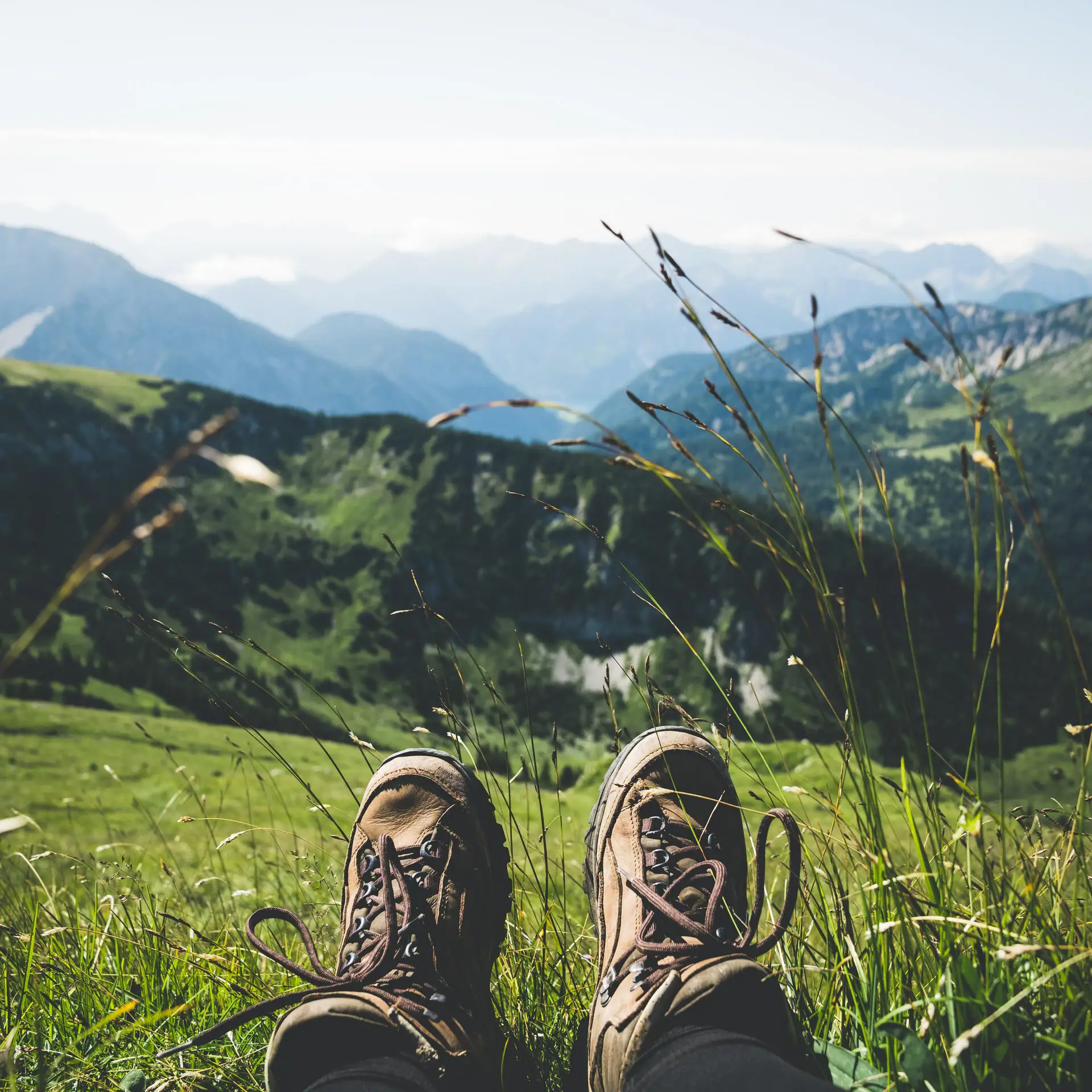 Hiking Legs of a person in a grassy area with mountains in the background.